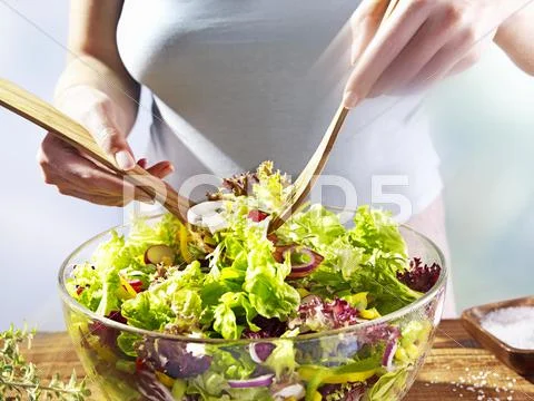 A Woman Mixing Salad In A Bowl