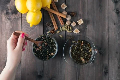 Woman mixing spoon herbal tea in glass jar Foto stock