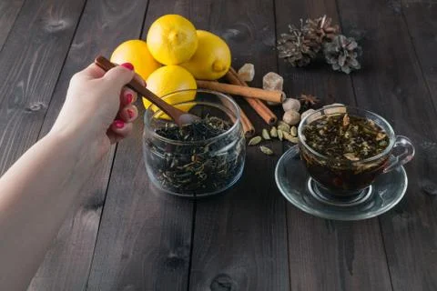 Woman mixing spoon herbal tea in glass jar Stock Photos