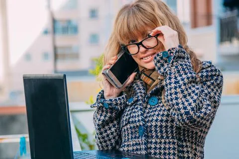 Woman with mobile phone and computer on the street Stock Photos