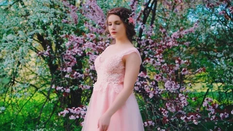 Woman model poses, trees blooming pink white flowers, spring garden green grass Stock Footage 234620848