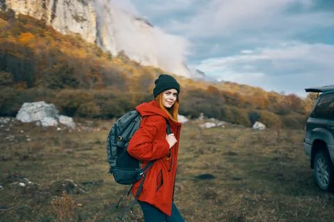 Woman model In a red jacket with a backpack in the fall outdoors warm hat fallen Stock Photos