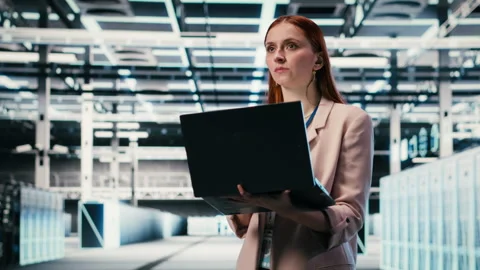 Woman in modern high tech server hub using notebook to do maintenance Stock Footage 330378524
