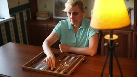 Woman Moving Checkers During Backgammon Game at Home Stock Footage 332639927