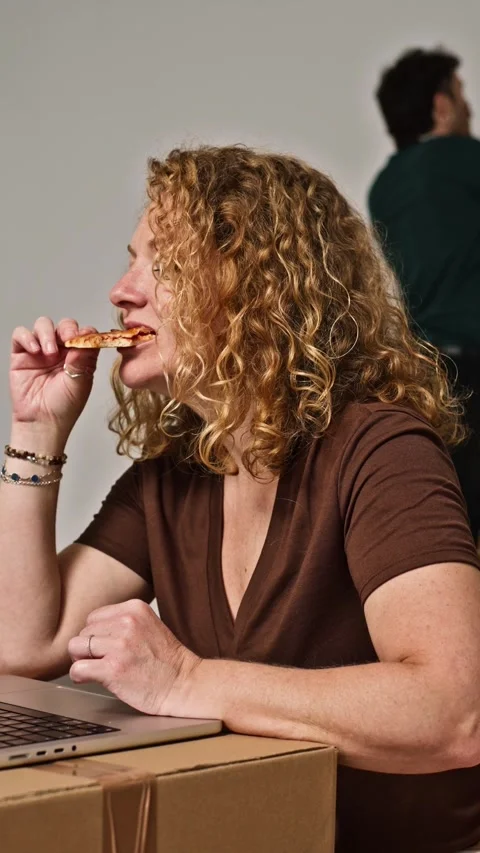 Woman multitasking working on laptop and eating pizza Video stock 343927433