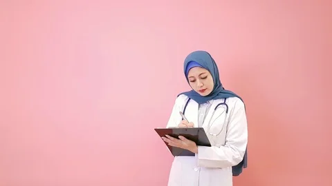 Woman muslim doctor writing patient medical record Stock Footage