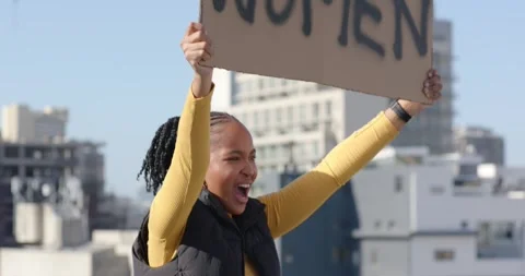 Woman in mustard top on rooftop protesting, raising arms, shouting and lifting Stock Footage 338356859