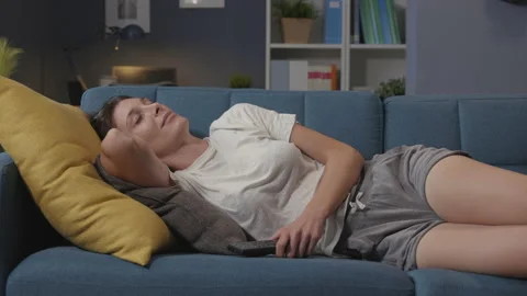 Woman napping on the sofa at home Stock Footage 150838866