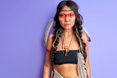 Woman in Native American indian wearing and colorful makeup posing at camera Stock Photos