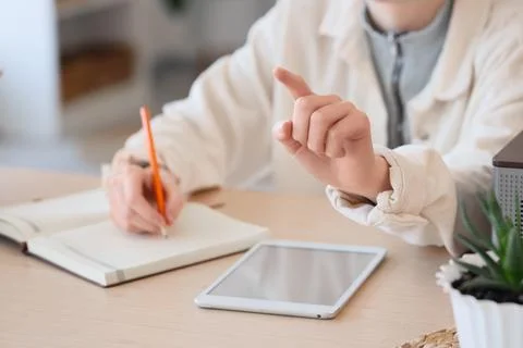 Woman with notebook and tablet computer using virtual screen at table in offi Stock Photos