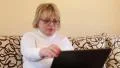 Woman with notebook. Senior woman types text uses laptop HD Footage
