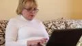 Woman with notebook. Senior woman types text using laptop HD Footage