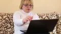 Woman with notebook. Senior woman types text uses laptop HD Footage