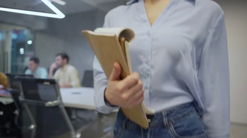 Woman with notepad walking down office corridor Stock Footage 132819150