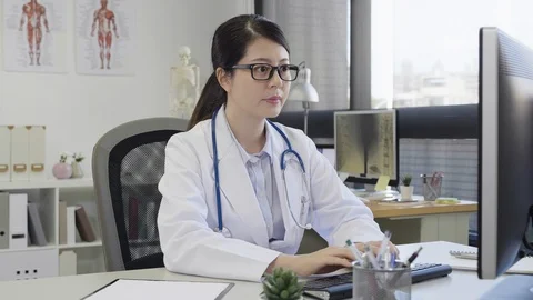 Woman nurse typing on computer keyboard Stock Footage 106546641