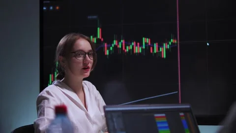 Woman in an office explains to her client on a chart the importance of Stock Footage 317165452