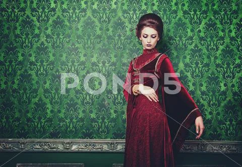 Woman In Old Styled Clothes On Green Vintage Pattern Background