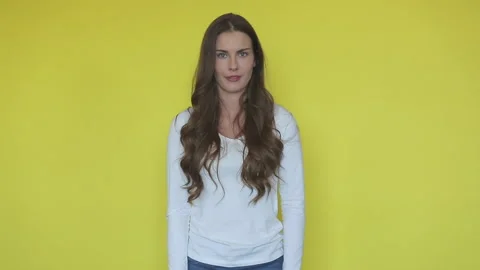 Woman oops face in yellow studio. Portrait of sorry girl emotion Stock Footage 137585375