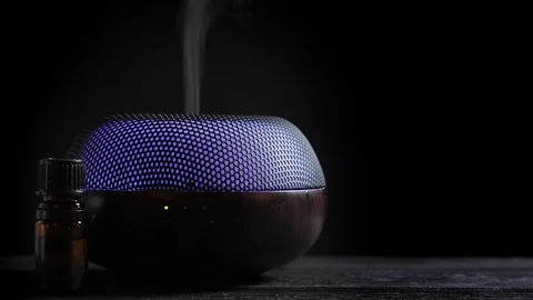 Woman open Diffuser for essential oil on black wooden table Stock Footage 122694624