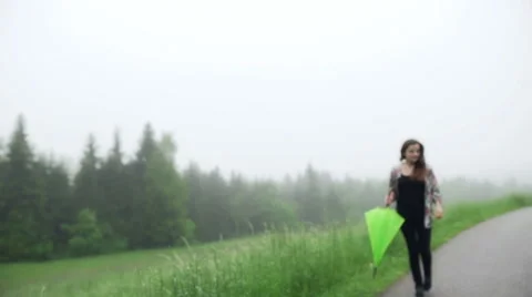 Woman open umbrella while walking on the road Stock Footage 51798993