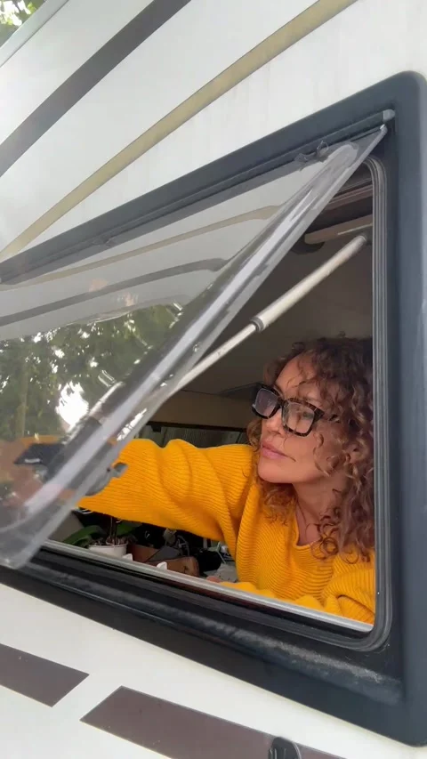 Woman opening the camper van window Stock Footage 344856560