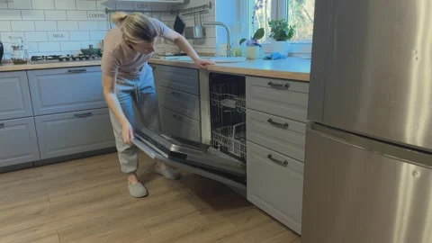 Woman opening dishwasher and pulling out lower rack, Concept of kitchen routine Video stock 341865299