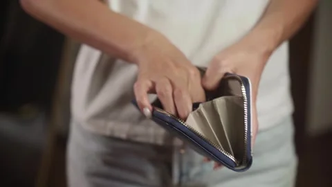 Woman opening empty wallet showing one coin Stock Footage 284845372
