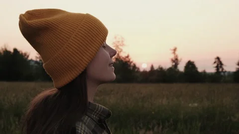 Woman is opening eyes while standing outside on fresh air during sunset Stock Footage 200462173
