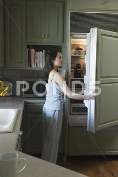 Woman Opening Refrigerator Door