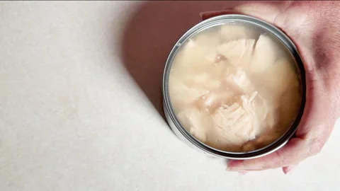 Woman opens can of white premium chunk chicken Video stock 344905924