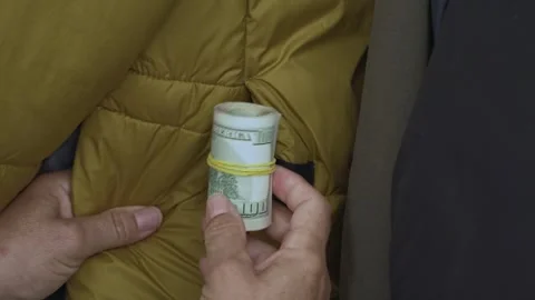 Woman opens closet and pulls out rolled dollar bills from a jacket pocket. Video stock 313610836