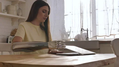 Woman opens laptop with shiny bionic arm to surf internet Stock Footage 150223929