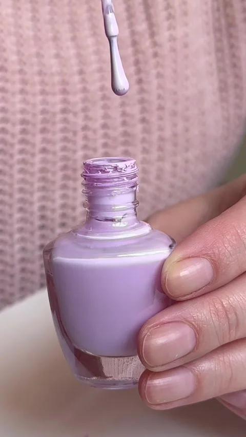 A woman opens for a nail opens a bottle with Stock Footage 255039214