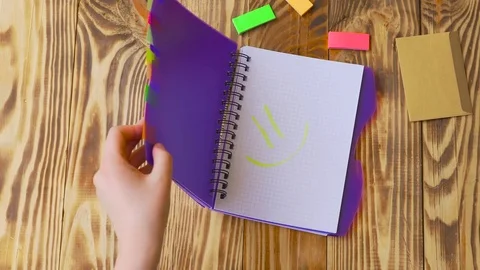 Woman opens notepad and draws smile. Video stock 77728148