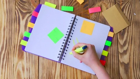 Woman opens notepad and draws smile. Open notepad with office supplies. Stock Footage 77728207