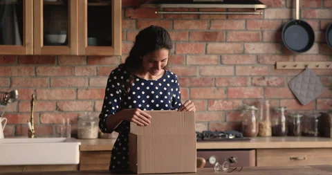 Woman opens parcel box checking ordered online goods feels satisfied 動画素材 148040431