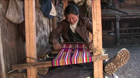A woman operates a basic loom in a Chinese village. Video stock 556314
