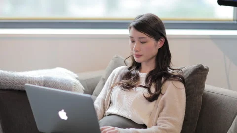 Woman operating a computer by the window Stock Footage 159725859