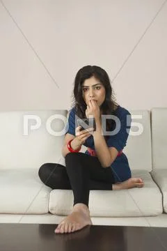Woman operating a remote control while watching tv Stock Photos