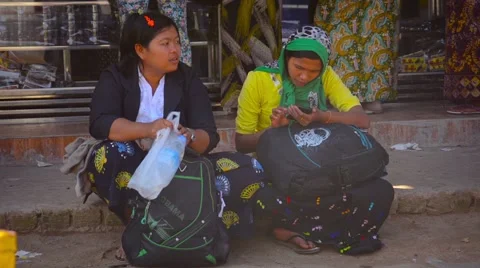 Woman operating a smart phone while sitting on a dusty sidewalk Stock Footage 55455947