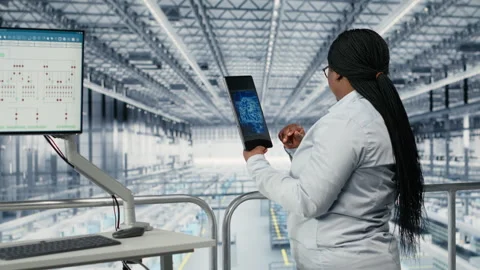 Woman optimizes microchip factory workflow with coworker, using EDA software 库存影片 333384582