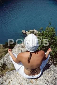 Woman outdoors doing yoga on cliff Stock Photos