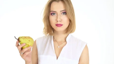 Woman over white background eats fruit Stock Footage