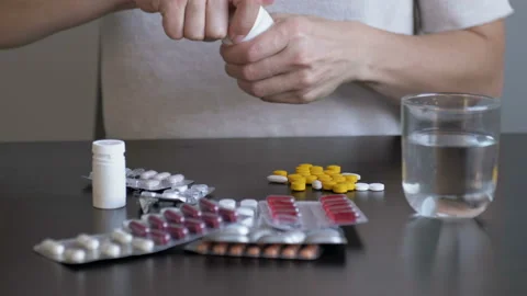 Woman overdosing pills to commit suicide at home. Depressed girl committing Video stock 118662294