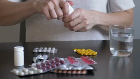 Woman overdosing pills to commit suicide at home. Depressed girl committing Stock Footage 127502173