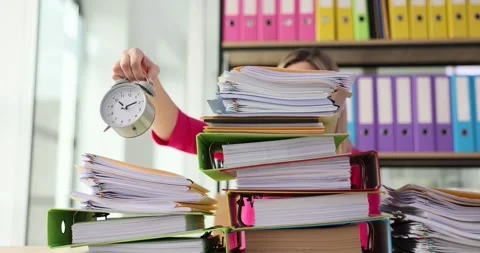 Woman is overwhelmed by a large stack of paper files in her office and holds an Stock Footage 281936855