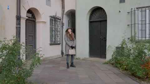 A woman is pacing back and forth while waiting for a date in a courtyard. Stock Footage 311708185