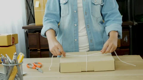Woman packing box on table checking goods package delivery shipping to customer. Stock Footage 154977653