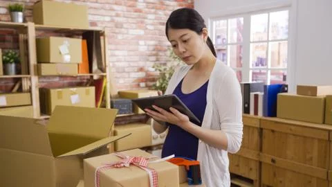 Woman packing boxes stack of parcels with pad Stock Photos