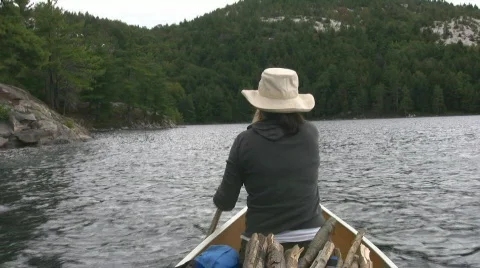 Woman paddles canoe. POV from stern. Stock Footage